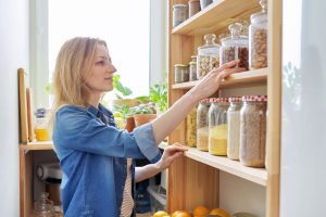 Woman organizing jars of food in her pantry