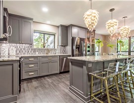 A beautiful luxury kitchen with gray cabinets and wood flooring